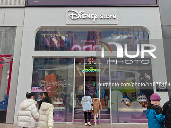 Customers walk past a newly opened Disney store on Nanjing Road Pedestrian Street in Shanghai, China, on December 18, 2024. (