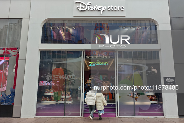 Customers walk past a newly opened Disney store on Nanjing Road Pedestrian Street in Shanghai, China, on December 18, 2024. 