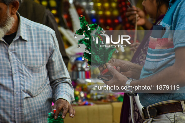 A man shops for a miniature Christmas tree at a marketplace in Kolkata, India, on December 18, 2024. 