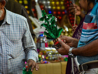 A man shops for a miniature Christmas tree at a marketplace in Kolkata, India, on December 18, 2024. (