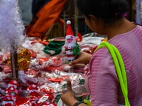 A lady shops for a miniature Santa Claus doll at a marketplace ahead of Christmas in Kolkata, India, on December 18, 2024. (