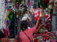 A lady shops for a Santa Claus doll as a shop sells decoration items for Christmas at a market in Kolkata, India, on December 18, 2024. (