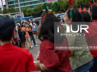 People take photos during the Christmas Carol to celebrate the upcoming Christmas in Jakarta, Indonesia, on December 18, 2024. This world's...