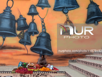 A woman sells flowers outside a temple in Prayagraj, India, on December 18, 2024. (