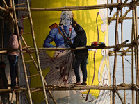 An artist creates a mural painting of the Hindu God Shri Ram on a pillar of the Shastri bridge over the river Ganges as part of the ongoing...