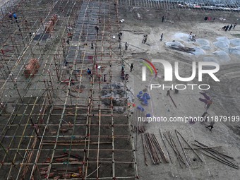 Labourers prepare a religious pandal or tent ahead of the upcoming Maha Kumbh Mela festival 2025 in Prayagraj, India, on December 18, 2024....