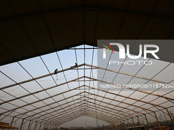 Labourers prepare a religious pandal or tent ahead of the upcoming Maha Kumbh Mela festival 2025 in Prayagraj, India, on December 18, 2024....