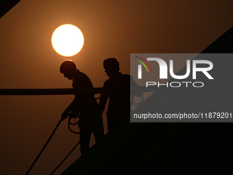 Labourers prepare a religious pandal or tent ahead of the upcoming Maha Kumbh Mela festival 2025 in Prayagraj, India, on December 18, 2024....