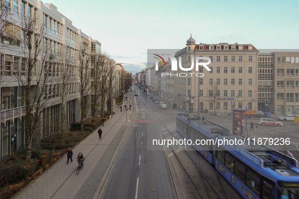 A tram travels along Bayerstrasse in Munich, Bavaria, Germany, on December 17, 2024. Pedestrians, cyclists, and vehicles share the busy urba...