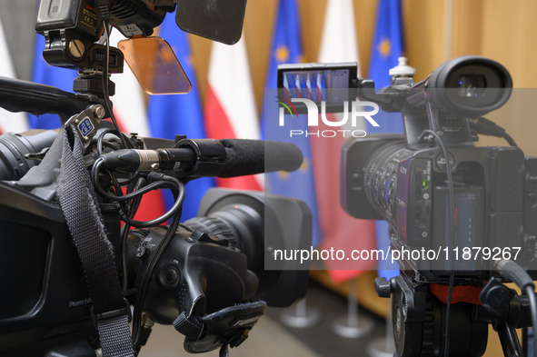 Video cameras are set against Poland's and EU flags before Polish Prime Minister Donald Tusk's press conference in Warsaw, Poland, on Decemb...