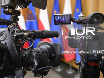 Video cameras are set against Poland's and EU flags before Polish Prime Minister Donald Tusk's press conference in Warsaw, Poland, on Decemb...