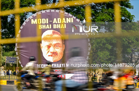 Motorists commute next to the banner that says ''Modi-Adani are brothers'' during a protest by Indian National Congress (INC) workers agains...