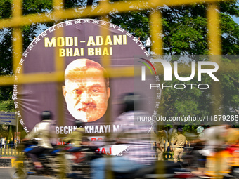 Motorists commute next to the banner that says ''Modi-Adani are brothers'' during a protest by Indian National Congress (INC) workers agains...