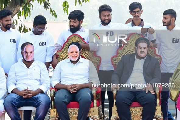 Indian National Congress (INC) workers wear masks of Indian industrialist and billionaire Gautam Adani (R), India's Prime Minister Narendra...