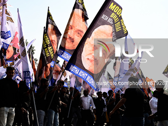 Indian National Congress (INC) workers carry flags that say ''Modi-Adani are brothers'' during a protest against the inaction of India's Pri...