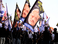 Indian National Congress (INC) workers carry flags that say ''Modi-Adani are brothers'' during a protest against the inaction of India's Pri...