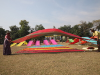 Weavers arrange sarees, a traditional cloth used for women's clothing, as they hang them out to dry after weaving at a workshop in Santipur...