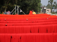 A weaver dries threads before weaving a saree, a traditional cloth used for women's clothing, at a workshop in Santipur town, about 80 km fr...