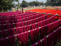 A weaver dries threads before weaving a saree, a traditional cloth used for women's clothing, at a workshop in Santipur town, about 80 km fr...