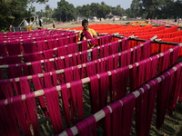 A weaver dries threads before weaving a saree, a traditional cloth used for women's clothing, at a workshop in Santipur town, about 80 km fr...