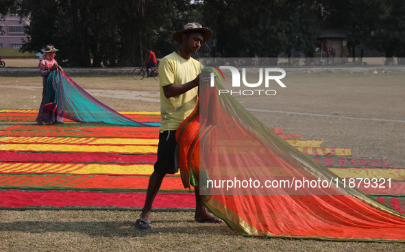 Weavers arrange sarees, a traditional cloth used for women's clothing, after weaving them at a workshop in Santipur town, about 80 km from K...