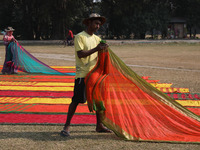 Weavers arrange sarees, a traditional cloth used for women's clothing, after weaving them at a workshop in Santipur town, about 80 km from K...