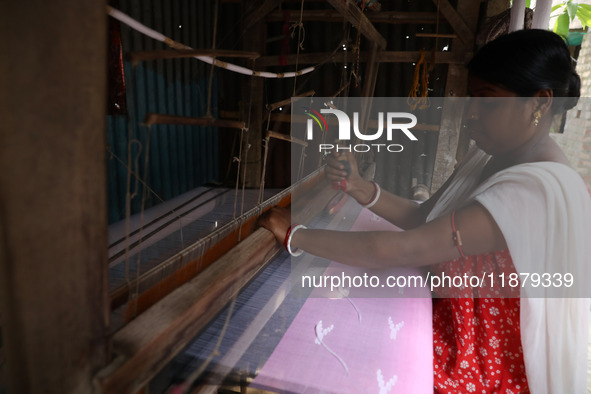 A weaver makes a saree, a traditional cloth used for women's clothing, on a hand loom at a workshop in Santipur town, about 80 km from Kolka...