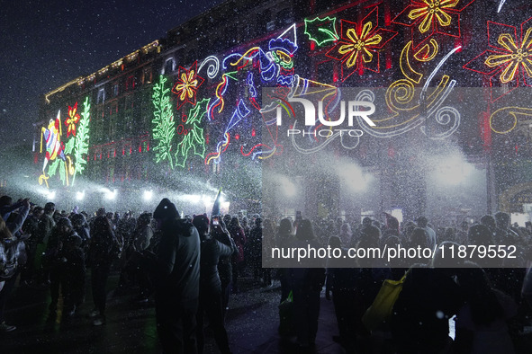 People enjoy the artificial snow during the opening of the 2024 Christmas Festival at the Zocalo in Mexico City, Mexico, on December 18, 202...