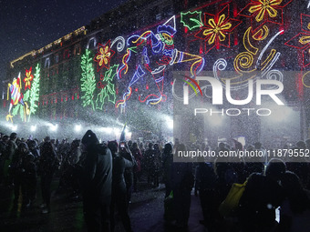 People enjoy the artificial snow during the opening of the 2024 Christmas Festival at the Zocalo in Mexico City, Mexico, on December 18, 202...