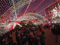 People walk under a light dome during the opening of the 2024 Christmas Festival at the Zocalo in Mexico City, Mexico, on December 18, 2024....