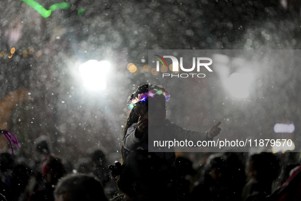 People enjoy the artificial snow during the opening of the 2024 Christmas Festival at the Zocalo in Mexico City, Mexico, on December 18, 202...