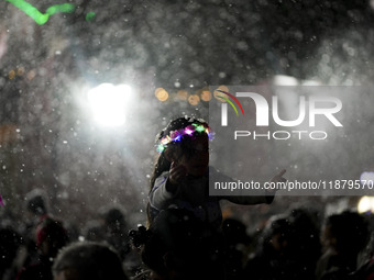 People enjoy the artificial snow during the opening of the 2024 Christmas Festival at the Zocalo in Mexico City, Mexico, on December 18, 202...