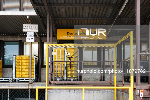 A Deutsche Post loading area in Munich, Germany, on December 18, 2024, contains yellow postal containers and trolleys positioned in the load...