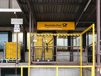 A Deutsche Post loading area in Munich, Germany, on December 18, 2024, contains yellow postal containers and trolleys positioned in the load...