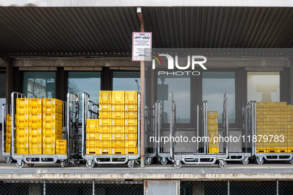 A Deutsche Post loading area in Munich, Germany, on December 18, 2024, contains yellow postal containers and trolleys positioned in the load...