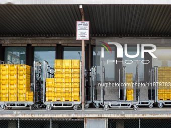 A Deutsche Post loading area in Munich, Germany, on December 18, 2024, contains yellow postal containers and trolleys positioned in the load...