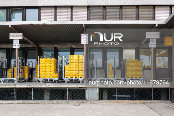 A Deutsche Post loading area in Munich, Germany, on December 18, 2024, contains yellow postal containers and trolleys positioned in the load...