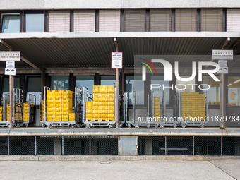 A Deutsche Post loading area in Munich, Germany, on December 18, 2024, contains yellow postal containers and trolleys positioned in the load...