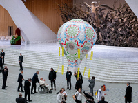 Pope Francis examines an air balloon presented to him at the end of the weekly general audience in The Vatican, on December 18, 2024, at Pau...