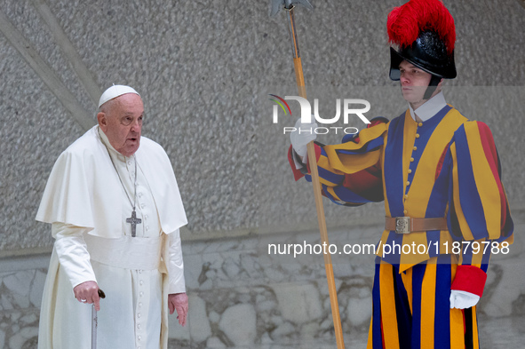 Pope Francis walks in front of a Swiss Guard as he arrives for the weekly general audience in The Vatican, on December 18, 2024, at Paul-VI...