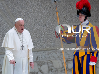 Pope Francis walks in front of a Swiss Guard as he arrives for the weekly general audience in The Vatican, on December 18, 2024, at Paul-VI...