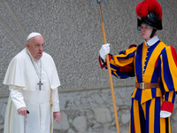 Pope Francis walks in front of a Swiss Guard as he arrives for the weekly general audience in The Vatican, on December 18, 2024, at Paul-VI...