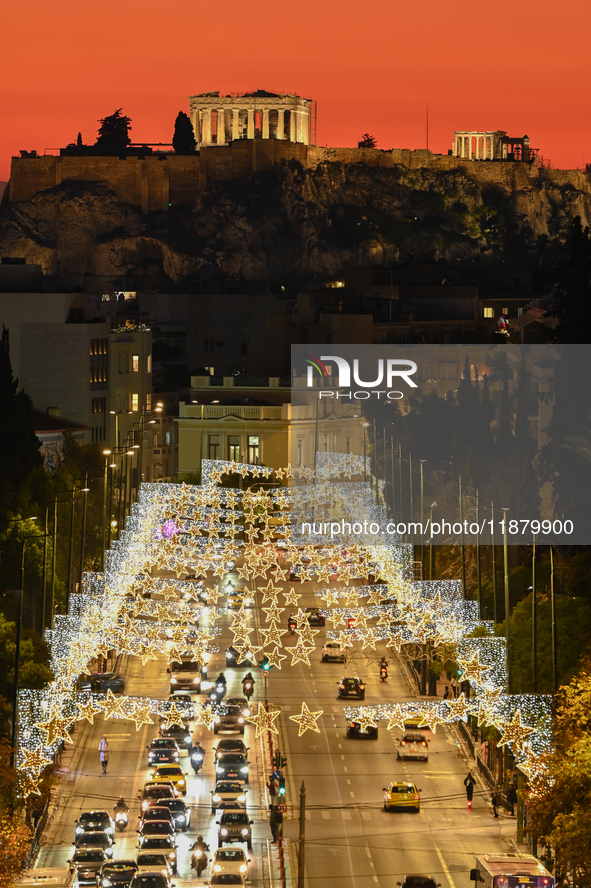 Christmas lights decorate a main street with the Acropolis in the background in Athens, Greece, on December 18, 2024. 