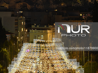 Christmas lights decorate a main street with the Acropolis in the background in Athens, Greece, on December 18, 2024. (