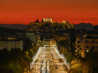 Christmas lights decorate a main street with the Acropolis in the background in Athens, Greece, on December 18, 2024. (