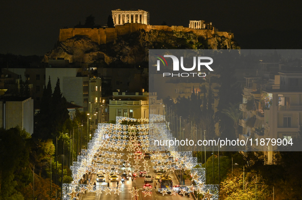 Christmas lights decorate a main street with the Acropolis in the background in Athens, Greece, on December 18, 2024. 