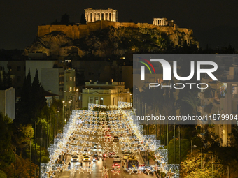 Christmas lights decorate a main street with the Acropolis in the background in Athens, Greece, on December 18, 2024. (