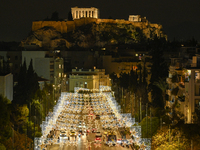 Christmas lights decorate a main street with the Acropolis in the background in Athens, Greece, on December 18, 2024. (