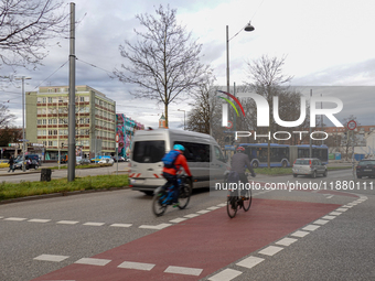 Cyclists, cars, and a bus are at an intersection in Munich, Bavaria, Germany, on December 18, 2024 (