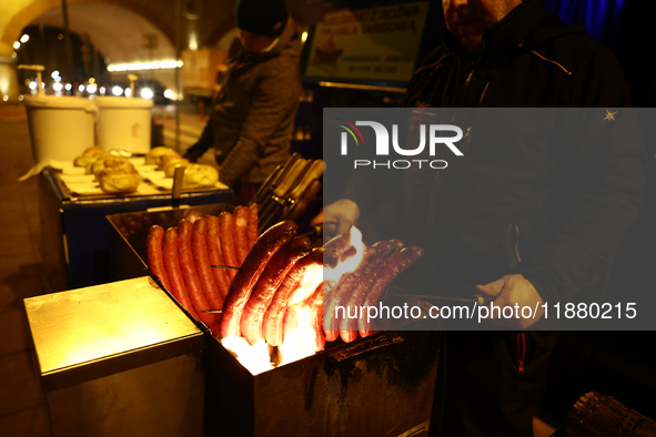 A person prepares sausages traditionally served at blue Nyska van in Krakow, Poland on December 18, 2024. 